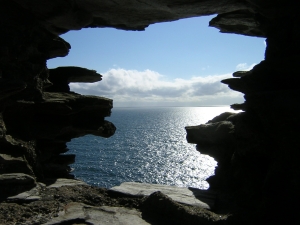 broken cliff face with open hole to sea